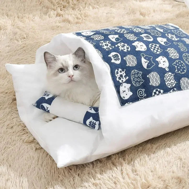 Cat lying on a white and blue cat bed nest with a blue patterned cover on a fluffy beige surface