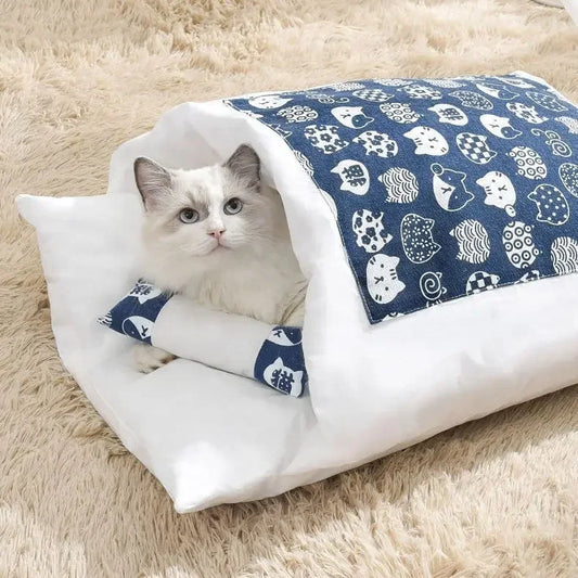 Cat lying on a white and blue cat bed nest with a blue patterned cover on a fluffy beige surface