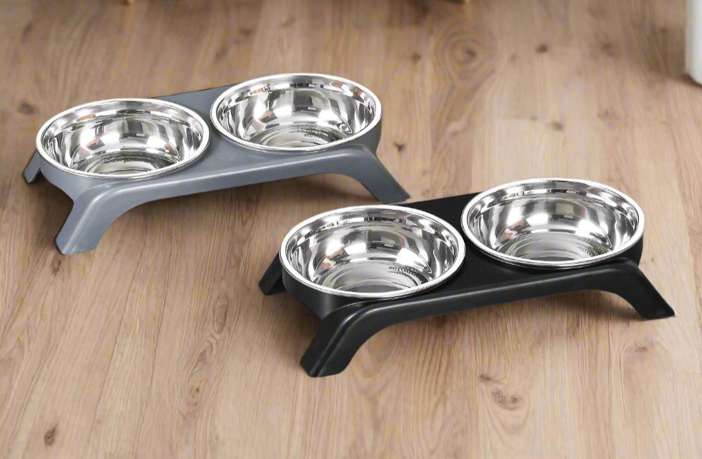Two elevated pet feeding stations with stainless steel bowls on a gray floor.