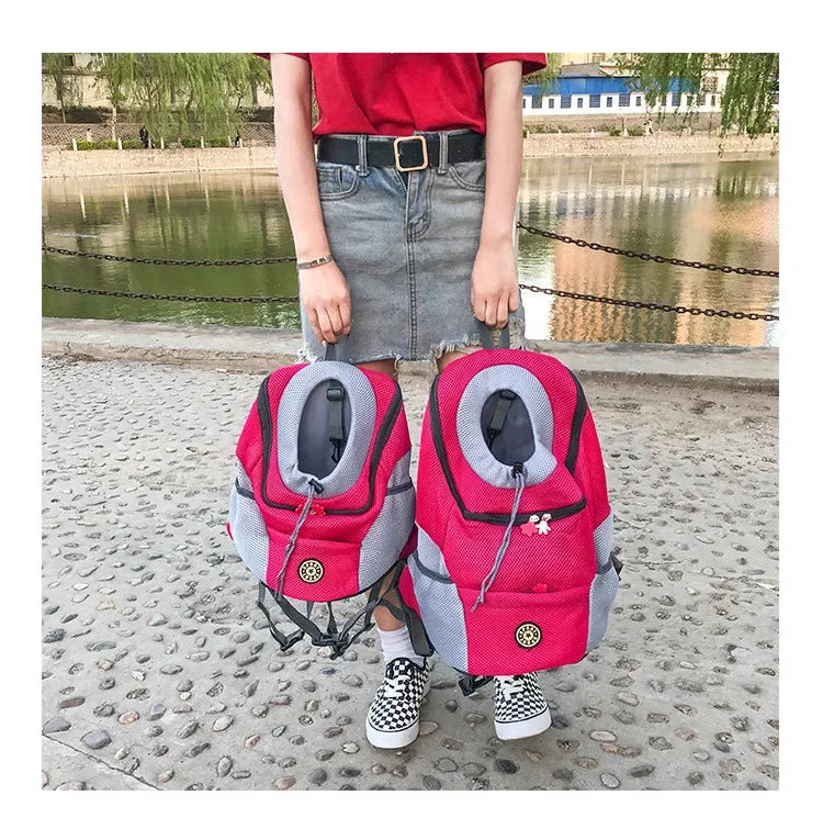 Person holding two pink pet carriers by a river