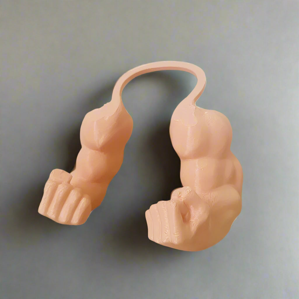 Pink muscular arm sculpture on a white surface