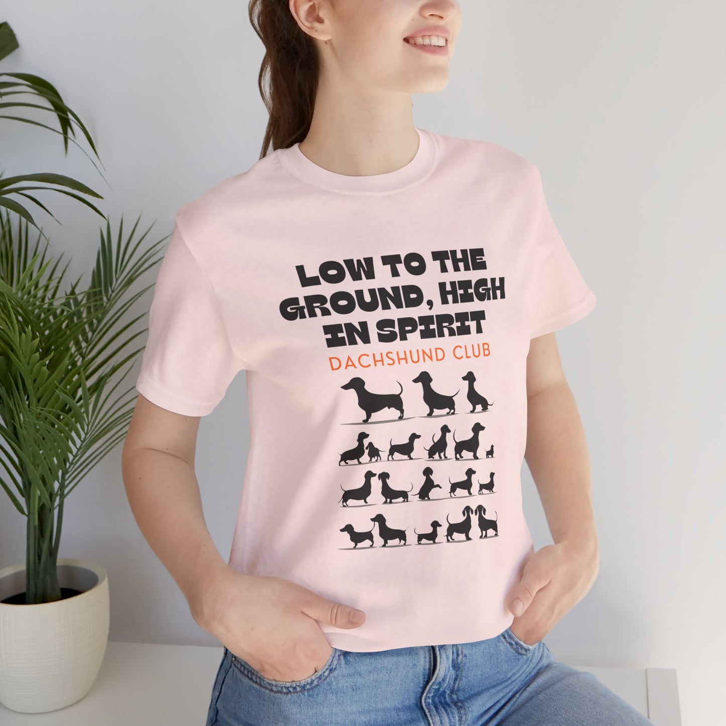 Woman wearing Soft Pink Dachshund Club t-shirt with sausage dog design