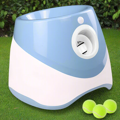 Light blue and white PawFetch automatic ball launcher on grass with three 2 inch mini tennis balls in front