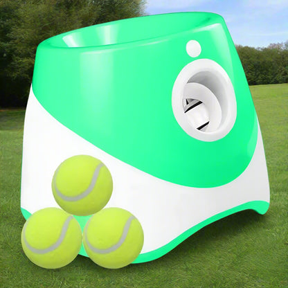 Lime green and white PawFetch automatic ball launcher on grass with three 2 inch mini tennis balls in front.