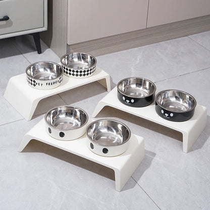 Set of stainless steel pet bowls on white stands in a kitchen setting