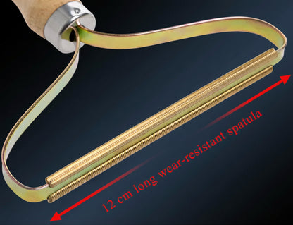 Person using a wooden-handle fabric shaver on a grey knit sweater, even strokes lifting pet hair and lint pills.