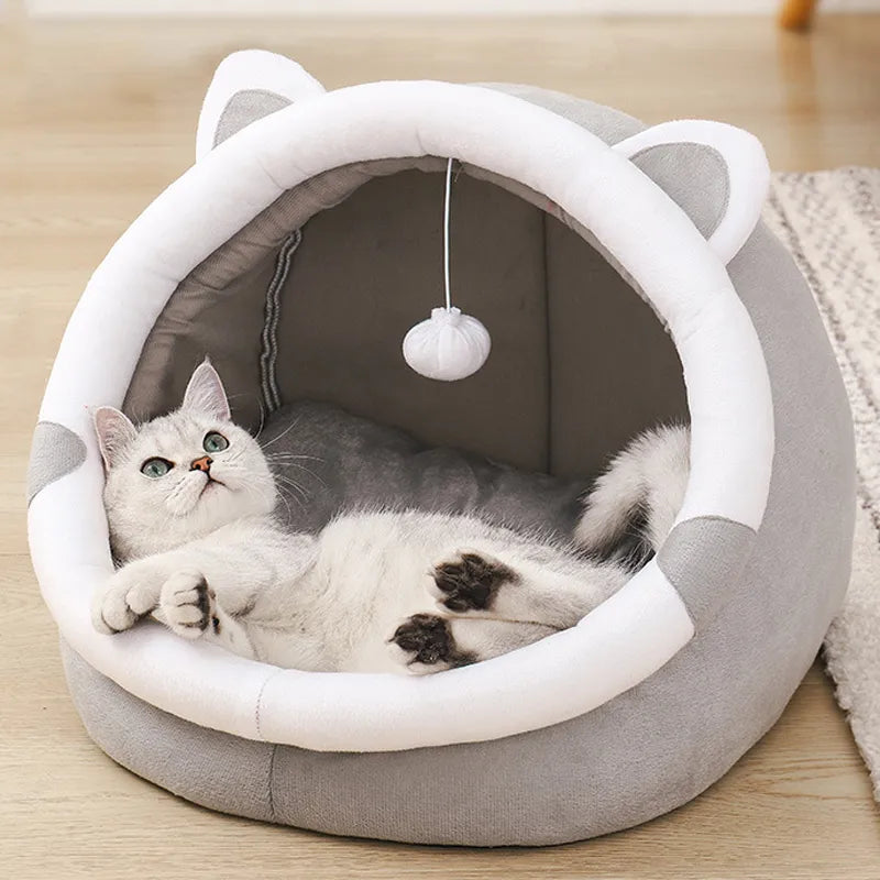 PawDome cat head cave bed in grey — front view showing half-open arch entrance and dangling pom-pom toy