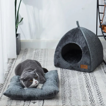 Grey plush igloo cat cave bed on a white background, dome shape with arched entrance opening, hang loop visible at apex
