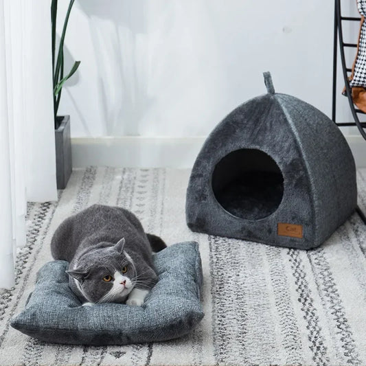 Grey plush igloo cat cave bed on a white background, dome shape with arched entrance opening, hang loop visible at apex