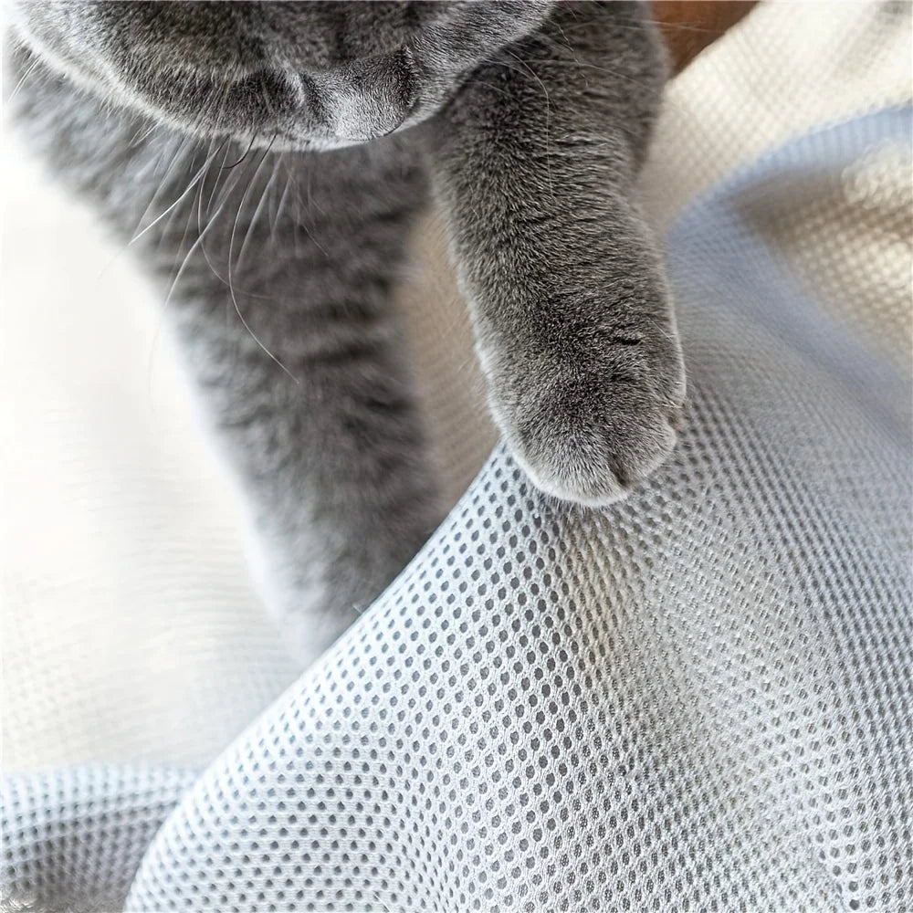  Close-up of the breathable open-weave mesh of the PawRest cat hammock bed with a grey cat's paw resting on it