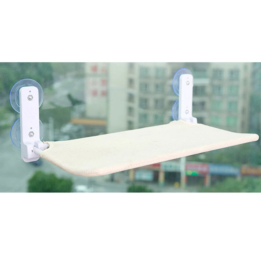 Off-white mesh cat window hammock stuck to a window with suction cups