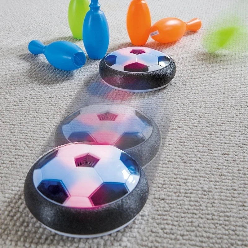 Electric hover football dog toy gliding across hardwood floor with LED light trail