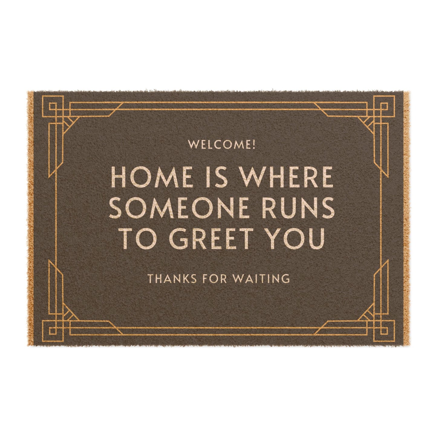 A rectangular doormat with the text 'WELCOME! HOME IS WHERE SOMEONE RUNS TO GREET YOU THANKS FOR WAITING' printed in black and gold colors.
