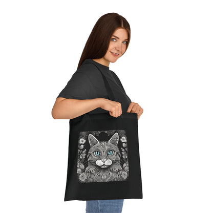 woman showing mandala cat cotton tote bag in black — monochrome cat face illustration with teal eyes, printed cotton, 42×38 cm