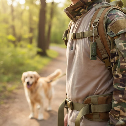 PawCall whistle clipped by its ball chain to a hiking rucksack strap, ready to use outdoors on a walk.