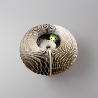 Cat paw reaching into PawCoil™ honeycomb cat scratcher ball track