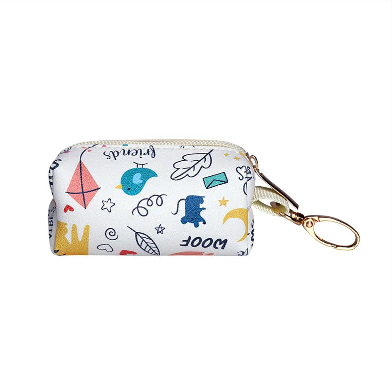 Blue and white brushstroke canvas dog poop bag holder with central dispensing port and gold carabiner attachment clip.