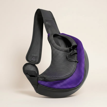 Purple hands-free pet sling carrier with adjustable padded strap and mesh side panel for cats and small dogs. 