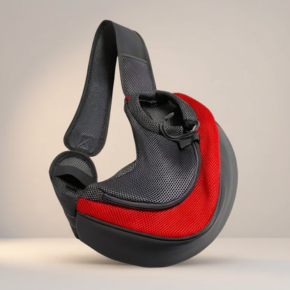 Red hands-free pet sling carrier with mesh side panel and padded over-shoulder strap for cats and toy-breed dogs.