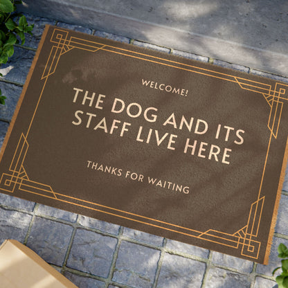 door mat saying the dog and its staff live here